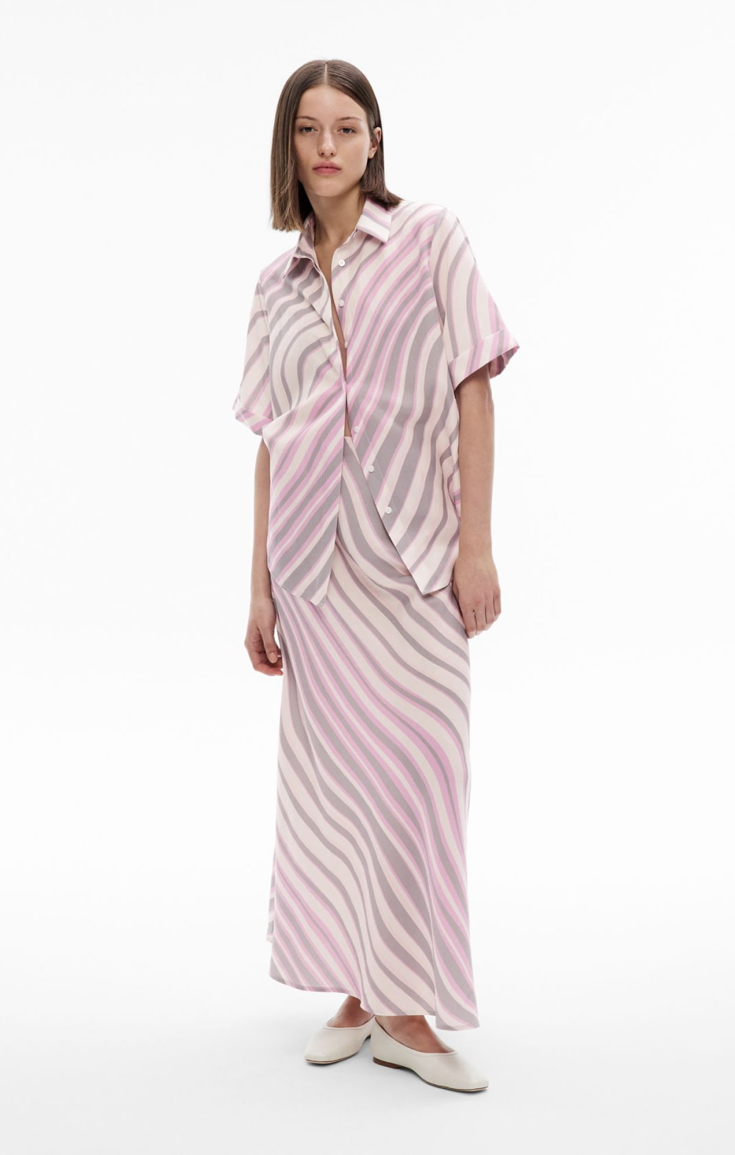 Woman wearing the short sleeve shirt, ruched midi skirt and alyssa ballet shoes